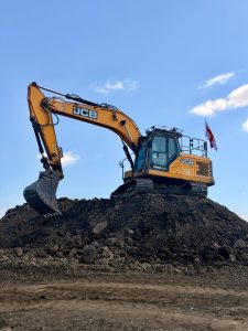 JCB excavator loading recycled aggregates at KCM Waste Management recycling facility